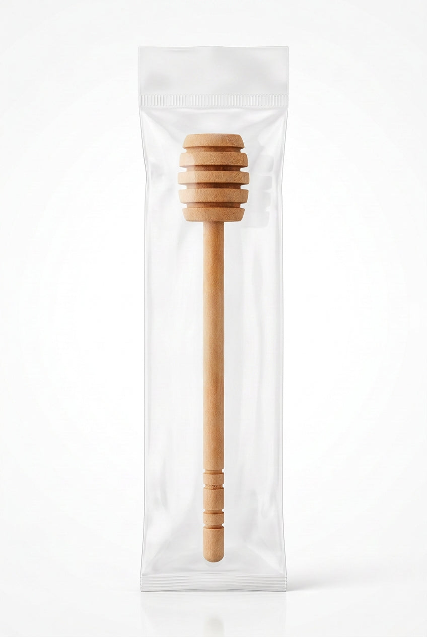 A natural wood honey dipper with a long handle and a ribbed spoon-like end, shown diagonally on a plain white background.