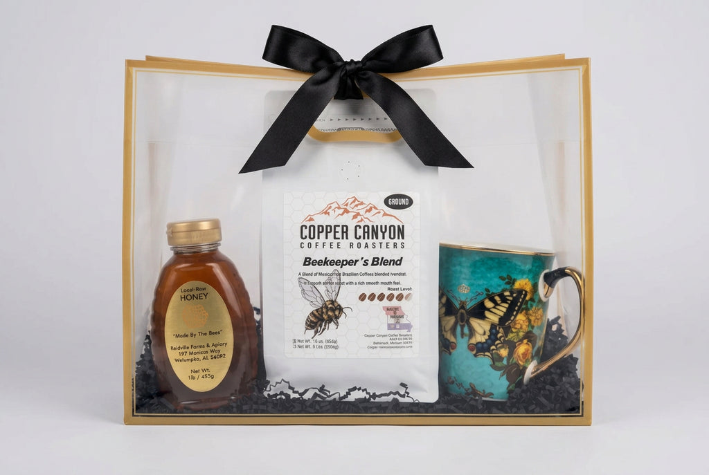 Gift bag with tan trim and black bowl.  Bottle of honey on the left, bag of copper canyon coffee in the middle and a butterfly coffee cup on the right. 