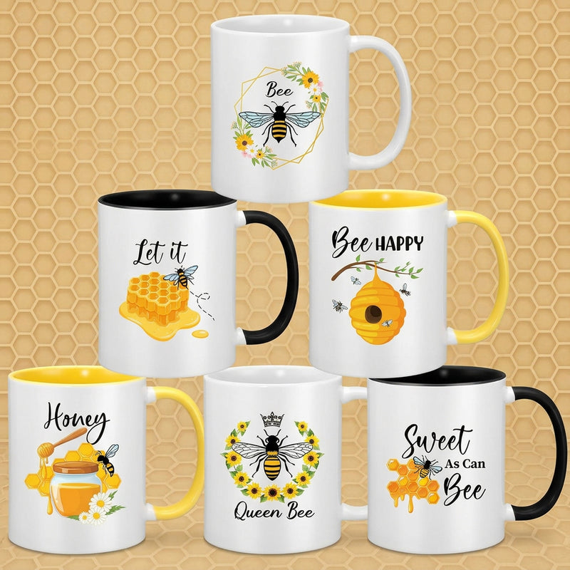 Seven white ceramic mugs with colorful bee and honeycomb designs, arranged in a pyramid on a plain white background. The mugs feature different printed phrases and handle colors in black, yellow, and white.